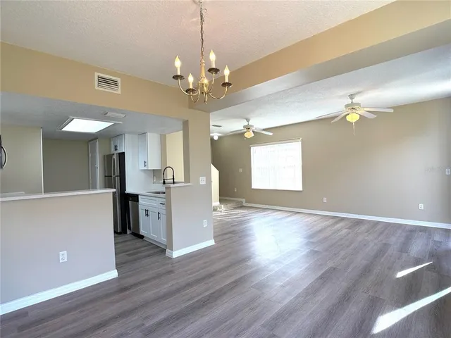 a view of a room with wooden floor and chandelier
