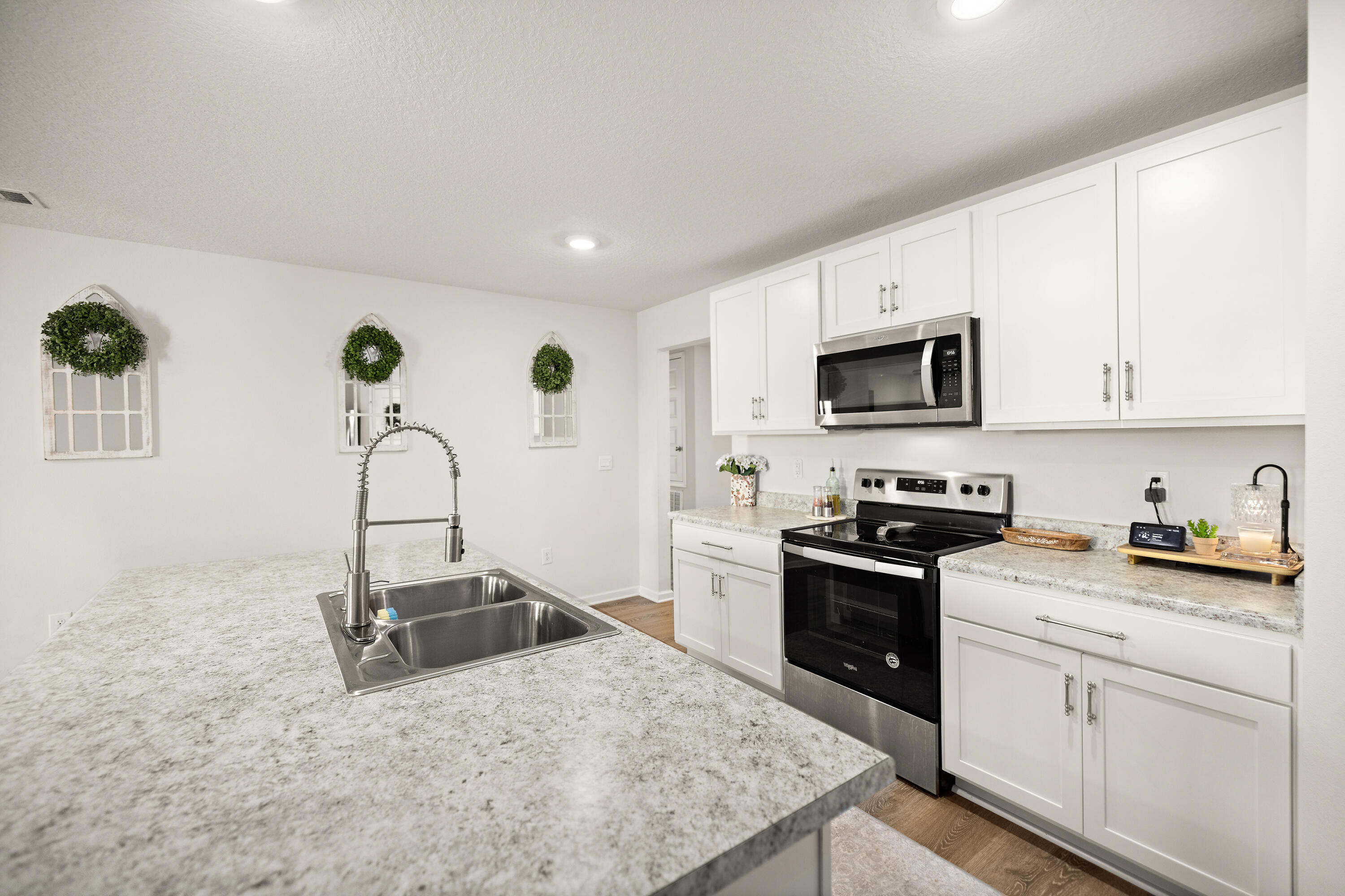 211 Laurel Hill Street Crestview, FL 32539 - Photo 11 of 60 a kitchen with granite countertop a sink a stove top oven and cabinetry