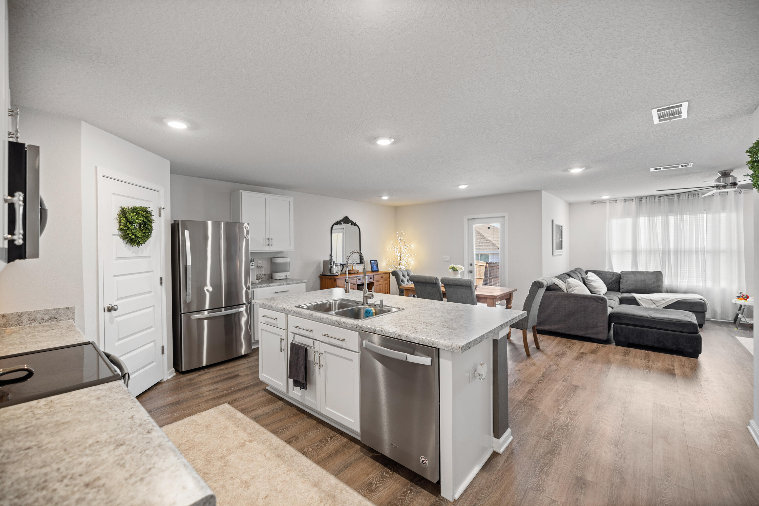 211 Laurel Hill Street Crestview, FL 32539 - Photo 14 of 60 a view of kitchen with stainless steel appliances kitchen island a stove a refrigerator a couch and a stove with wooden floor