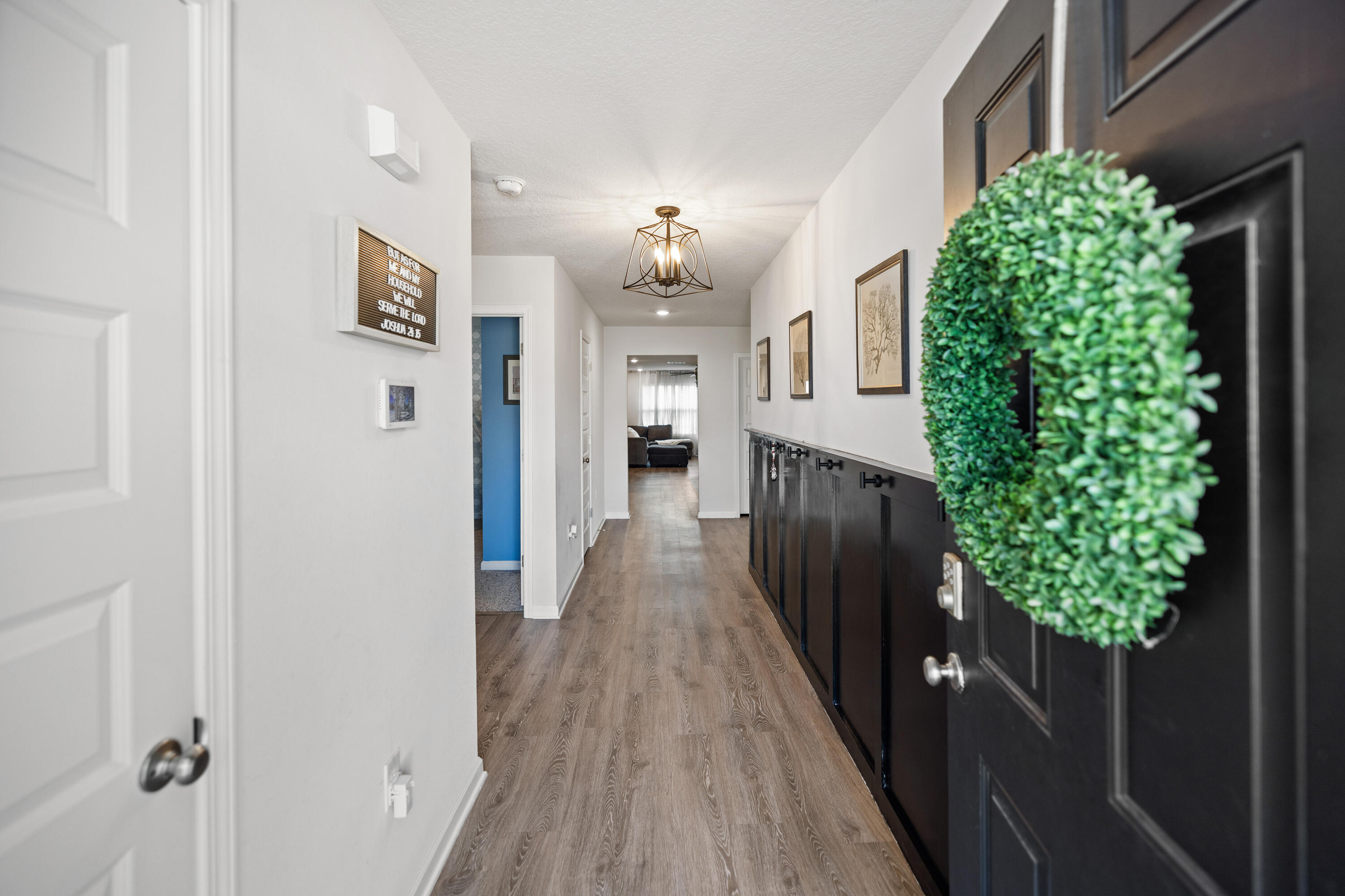 211 Laurel Hill Street Crestview, FL 32539 - Photo 5 of 60 a view of a hallway with wooden floor and a potted plant