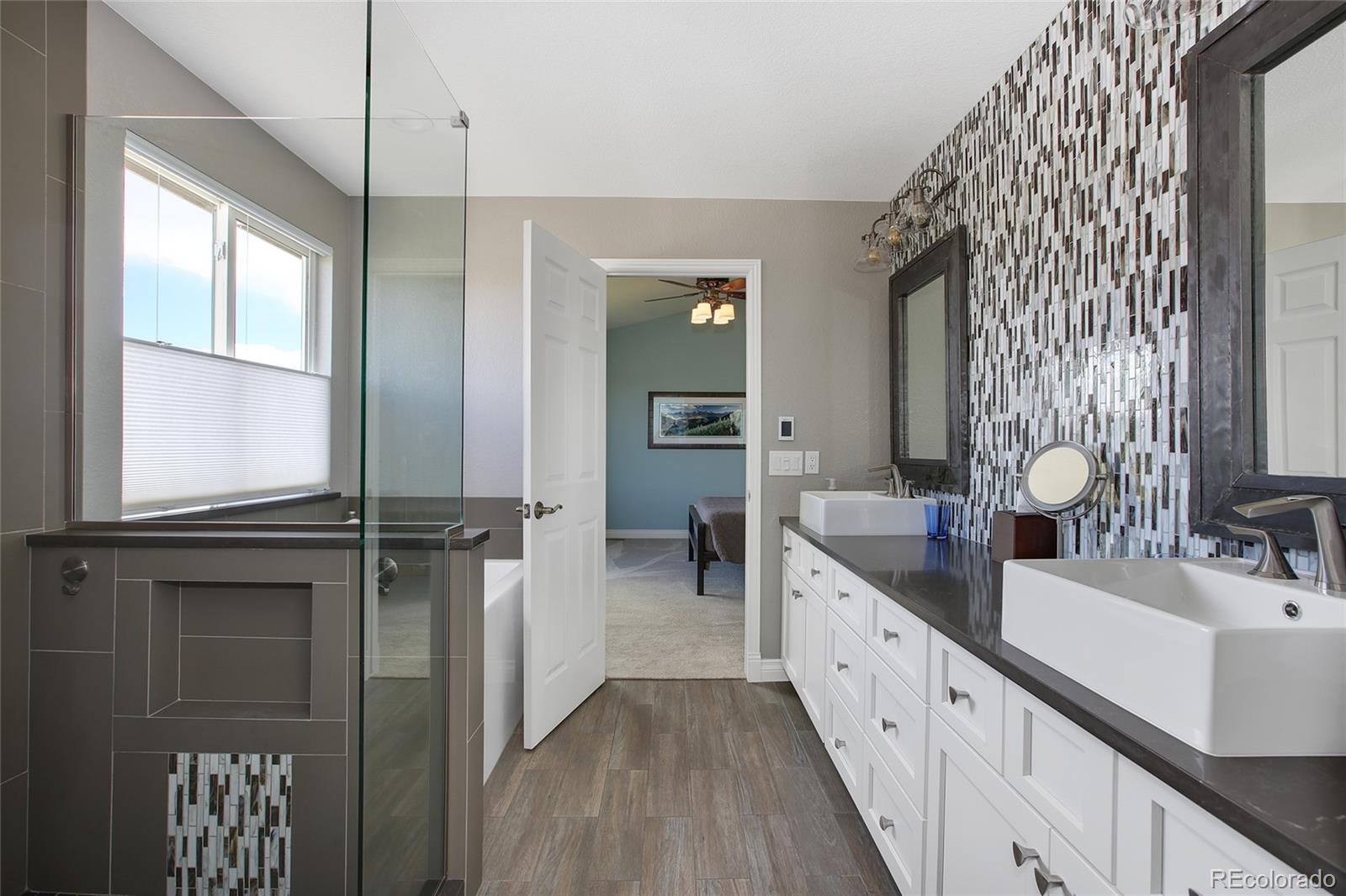 10274 Willowbridge Court Highlands Ranch, CO 80126 - Photo 19 of 35 a spacious bathroom with a double vanity sink a mirror and a shower