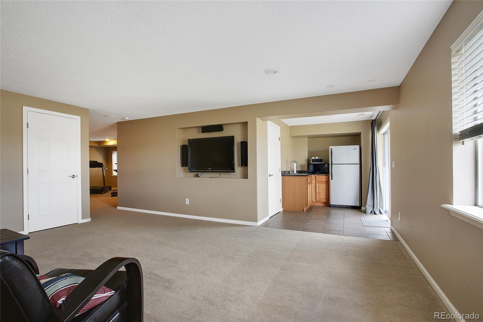 10274 Willowbridge Court Highlands Ranch, CO 80126 - Photo 26 of 35 a living room with furniture and a flat screen tv