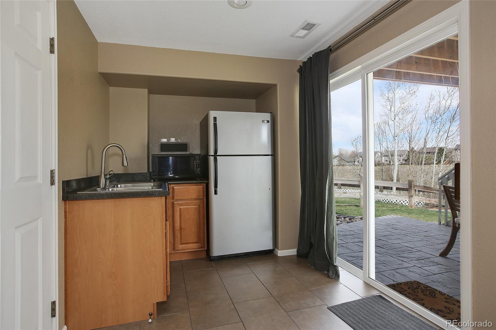 10274 Willowbridge Court Highlands Ranch, CO 80126 - Photo 29 of 35 a kitchen with stainless steel appliances granite countertop a refrigerator and a sink