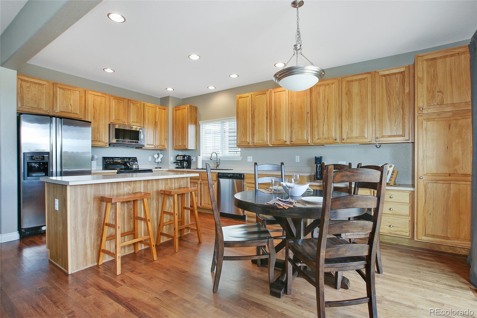 10274 Willowbridge Court Highlands Ranch, CO 80126 - Photo 9 of 35 a kitchen with stainless steel appliances granite countertop a dining table chairs refrigerator and sink