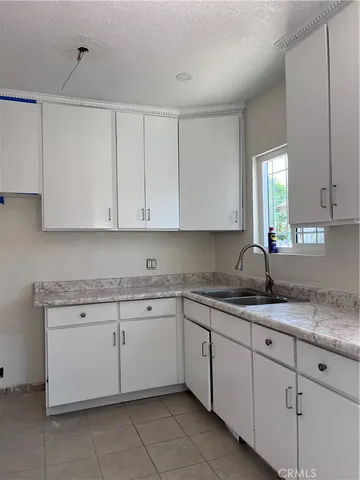 a kitchen with white cabinets stainless steel appliances sink and window