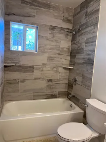 a bathroom with a toilet and a bath tub