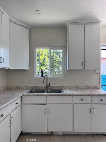 a kitchen with granite countertop white cabinets and white appliances