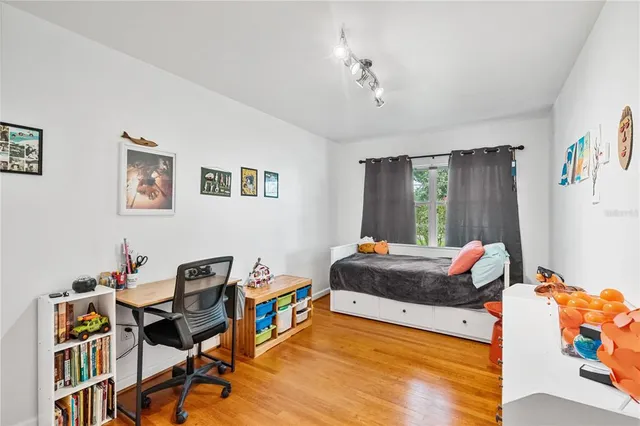 a bedroom with a bed window and a desk