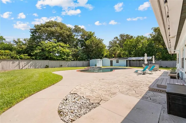 an aerial view of residential houses with outdoor space and trees