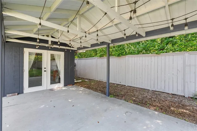 a view of a swimming pool with a yard and trees in the background