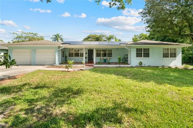 a view of a house with a yard and sitting area
