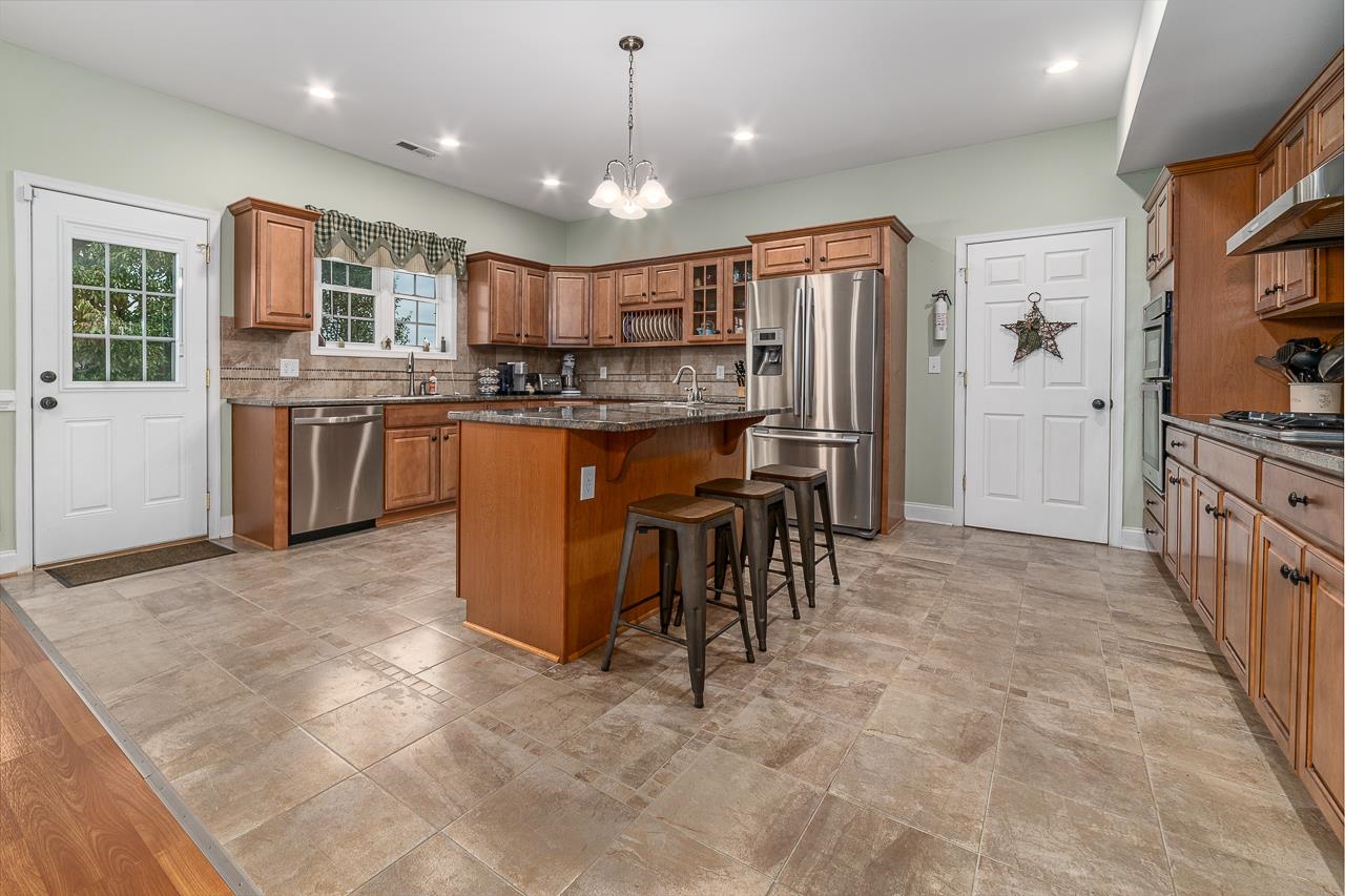 1733 Ridge Road Raphine, VA 24472 - Photo 13 of 32 a kitchen with stainless steel appliances granite countertop a refrigerator oven a sink a dining table and chairs with wooden floor