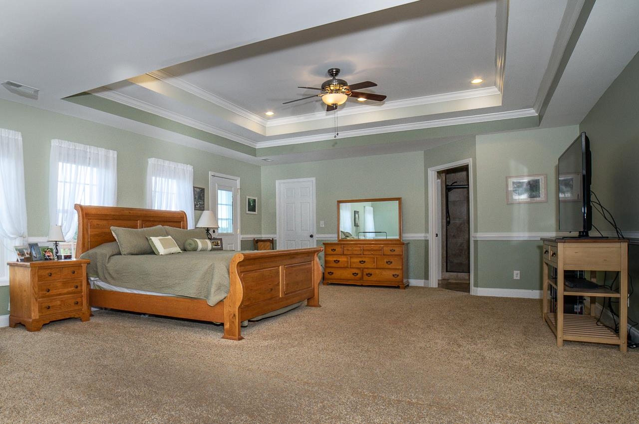 1733 Ridge Road Raphine, VA 24472 - Photo 19 of 32 a spacious bedroom with a bed and a chandelier