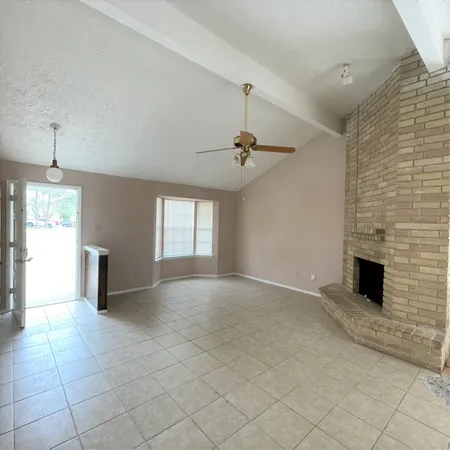 an empty room with windows and fireplace