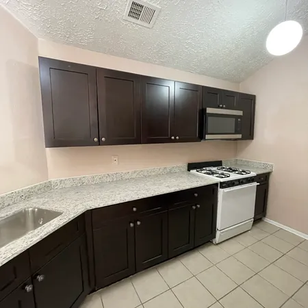 a kitchen with stainless steel appliances granite countertop a sink stove and microwave