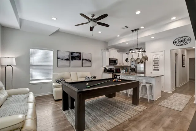 a kitchen with stainless steel appliances kitchen island granite countertop a table chairs sink and cabinets