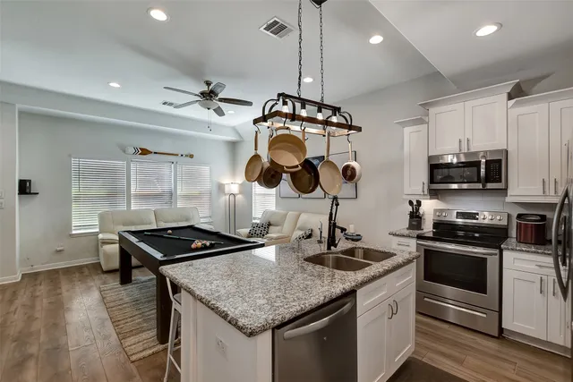 a kitchen with stainless steel appliances granite countertop a stove and a sink