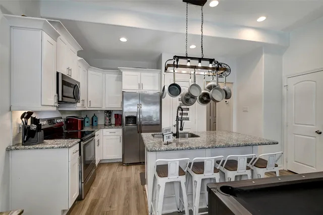 a kitchen with stainless steel appliances granite countertop a stove a sink and a refrigerator