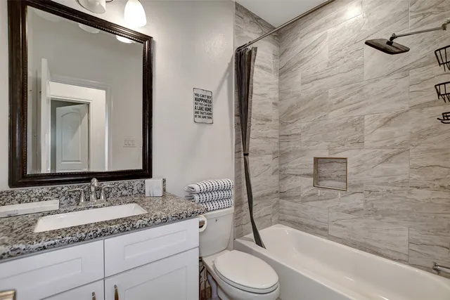 a bathroom with a granite countertop sink toilet and shower