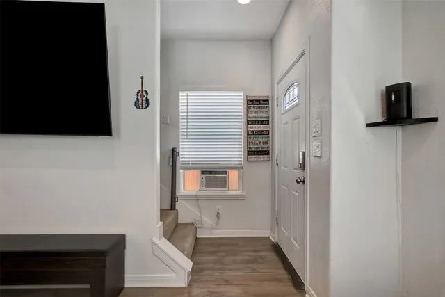 a view of a livingroom with wooden floor and staircase