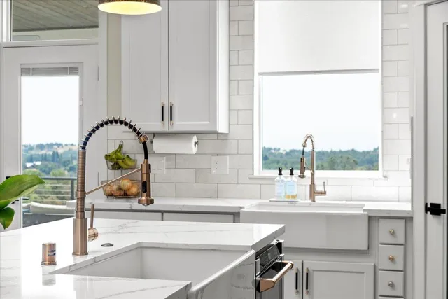a kitchen with a sink and a view of living room