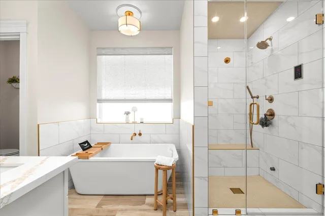 a bathroom with a tub sink and mirror