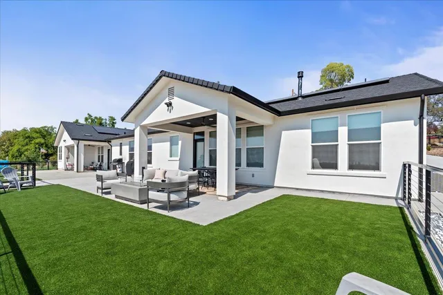 a view of a house with a backyard and a patio