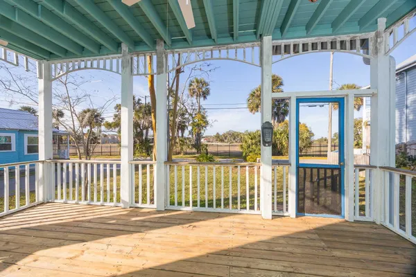 a view of an empty room with a window and a kitchen