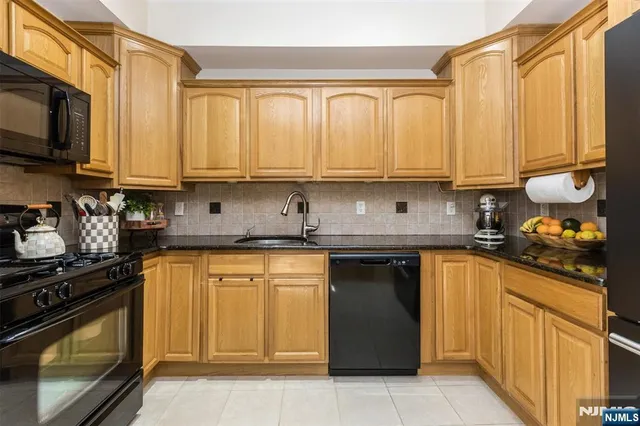 a kitchen with stainless steel appliances granite countertop a stove sink and cabinets
