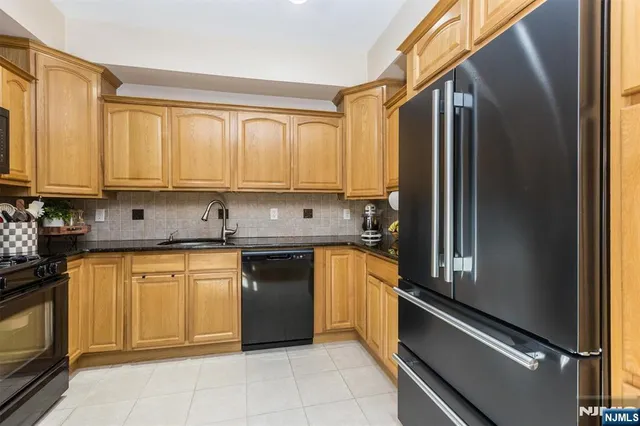a kitchen with stainless steel appliances granite countertop a refrigerator sink and stove