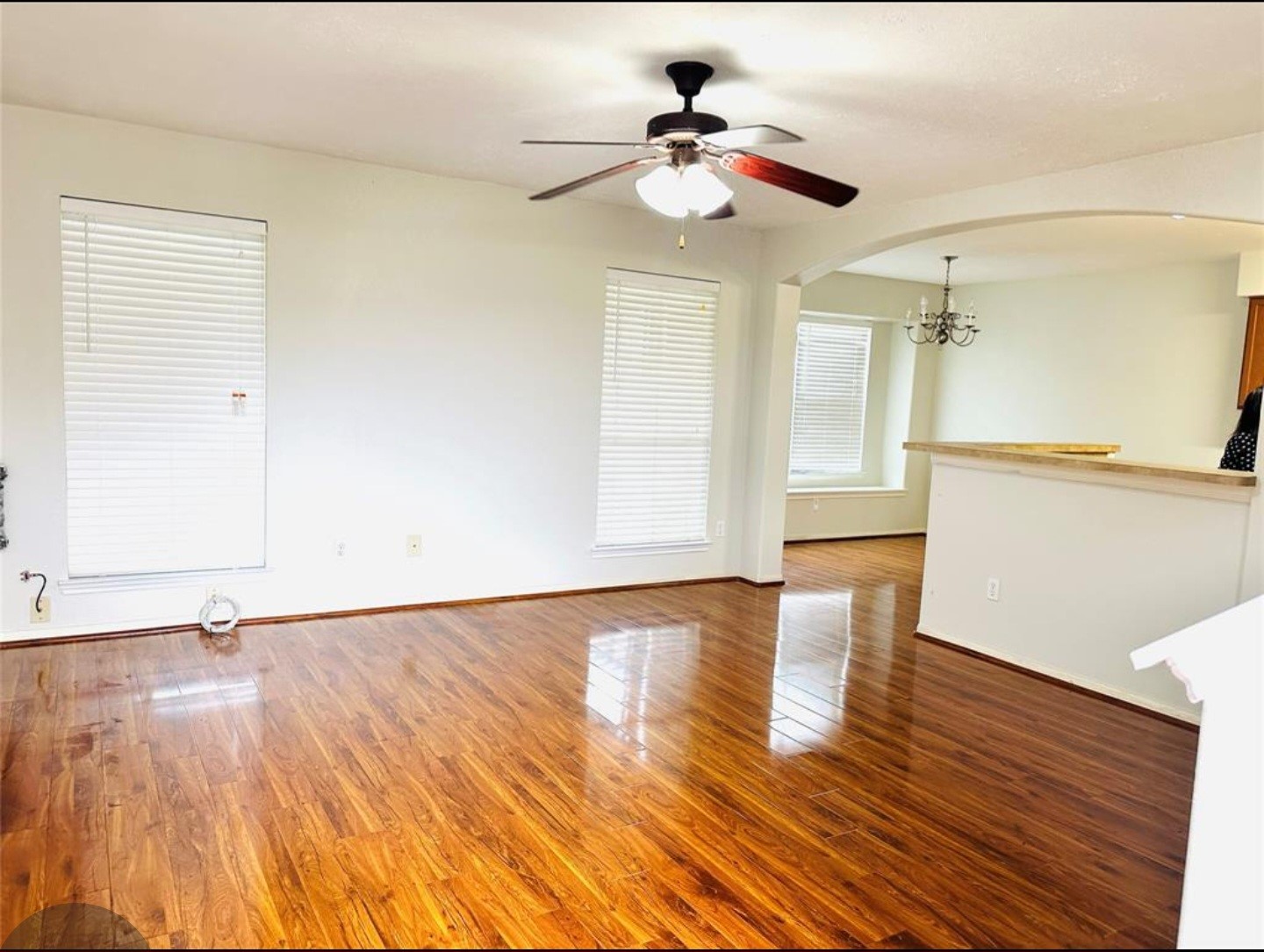 7203 Calcutta Spring Drive Houston, TX 77083 - Photo 3 of 14 a view of an empty room with wooden floor and a ceiling fan