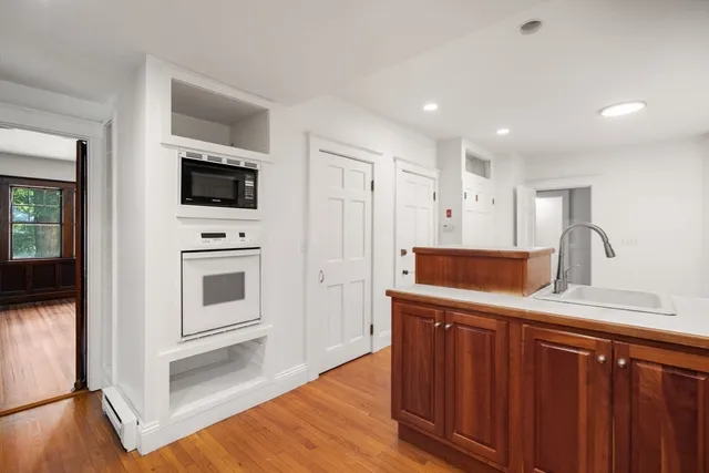 a kitchen with a refrigerator sink and wooden floor