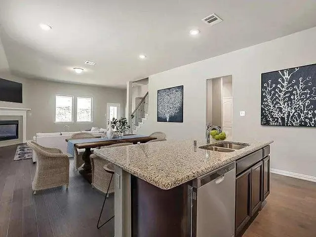 a kitchen with granite countertop kitchen island stainless steel appliances a table and chairs
