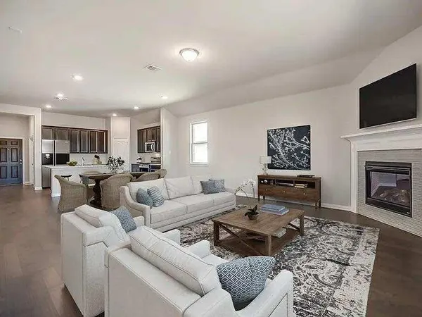 a living room with furniture a flat screen tv and a fireplace