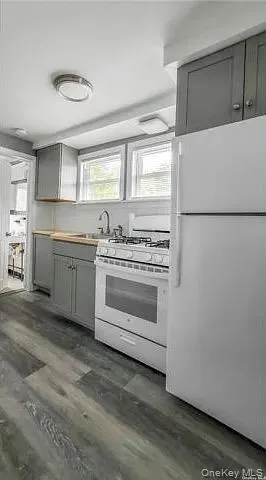 a kitchen with white cabinets and white appliances
