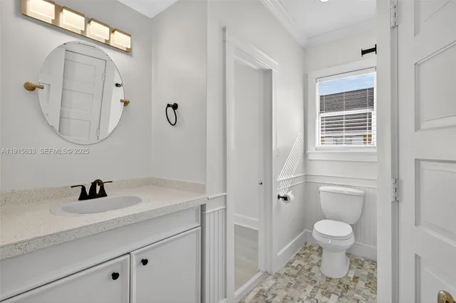 a bathroom with a toilet a sink and a mirror