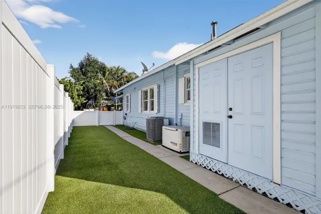 a view of a house with a small yard and wooden fence