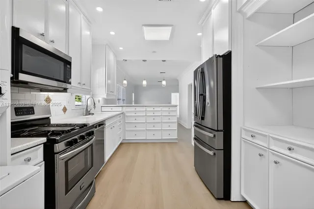 a kitchen with stainless steel appliances a refrigerator stove and microwave