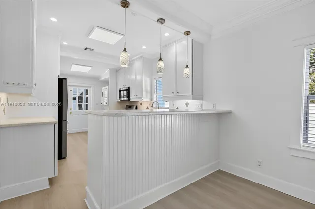 a kitchen with kitchen island a counter top space a sink and appliances