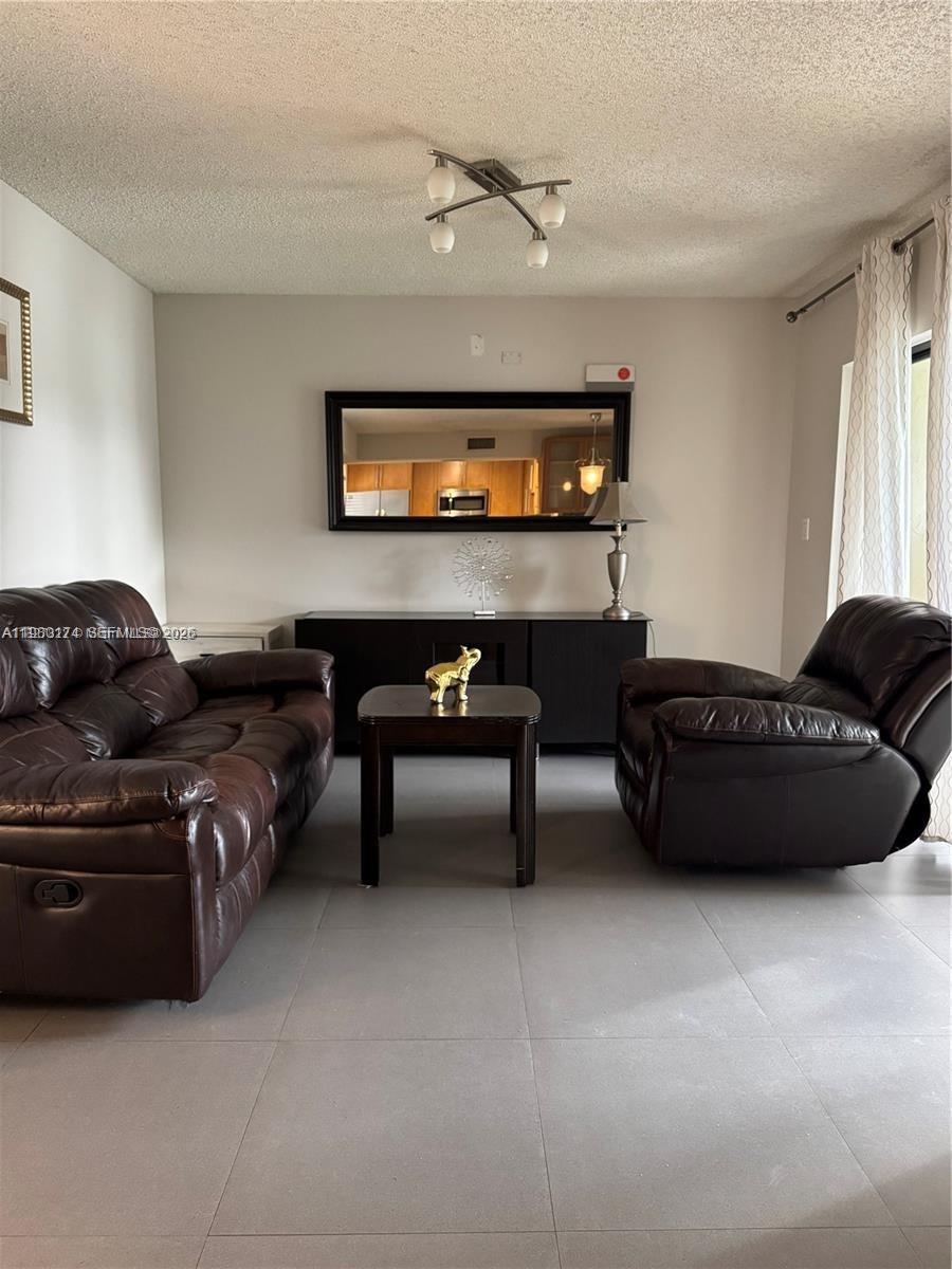 1226 North Hiatus Road, Unit 1226 Pembroke Pines, FL 33026 - Photo 6 of 10 a living room with furniture and a tv