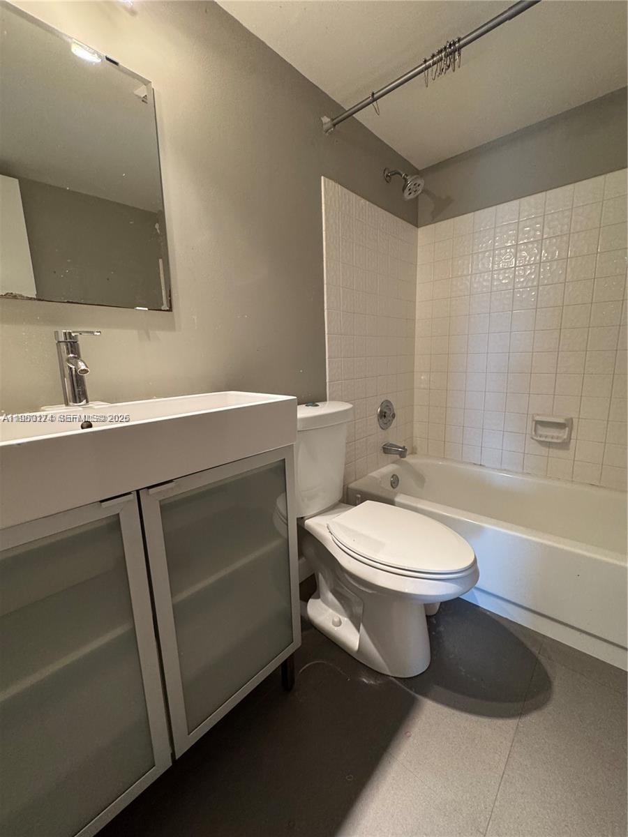 1226 North Hiatus Road, Unit 1226 Pembroke Pines, FL 33026 - Photo 8 of 10 a bathroom with a toilet a sink a mirror and bathtub