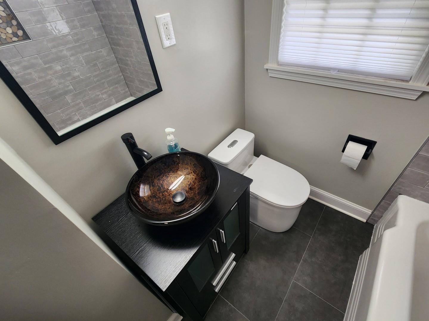 5259 Sequoia Road Memphis, TN 38120 - Photo 20 of 36 a bathroom with a toilet and a mirror