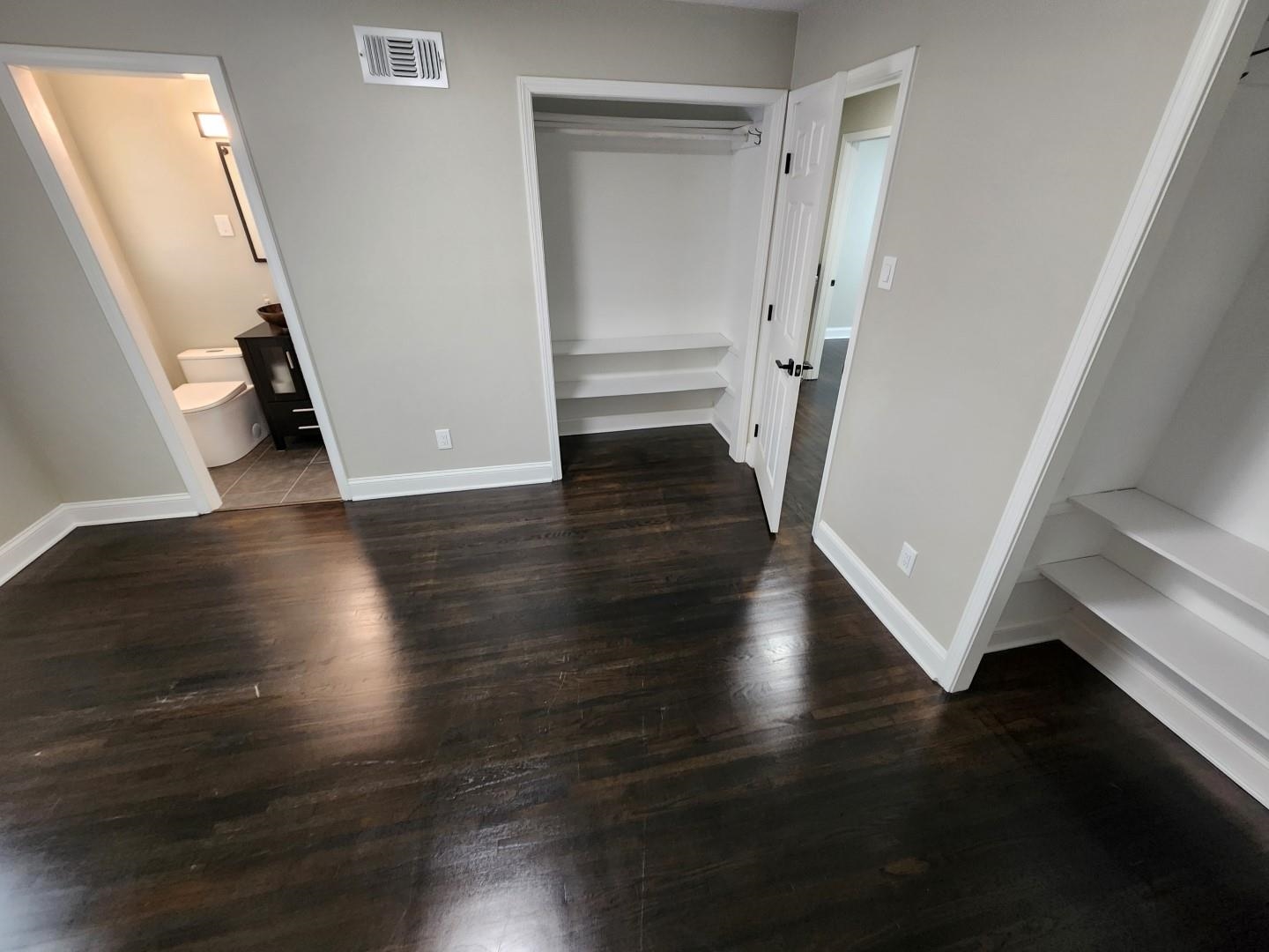 5259 Sequoia Road Memphis, TN 38120 - Photo 27 of 36 an empty room with wooden floor and staircase