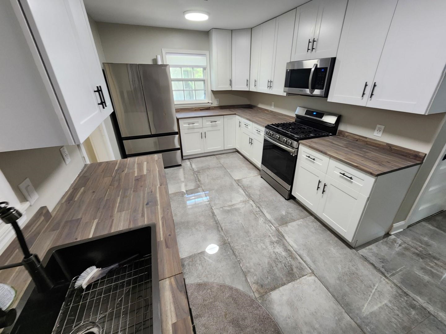 5259 Sequoia Road Memphis, TN 38120 - Photo 8 of 36 a kitchen with stainless steel appliances granite countertop a stove refrigerator and a microwave