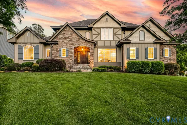 a front view of a house with a yard and green space