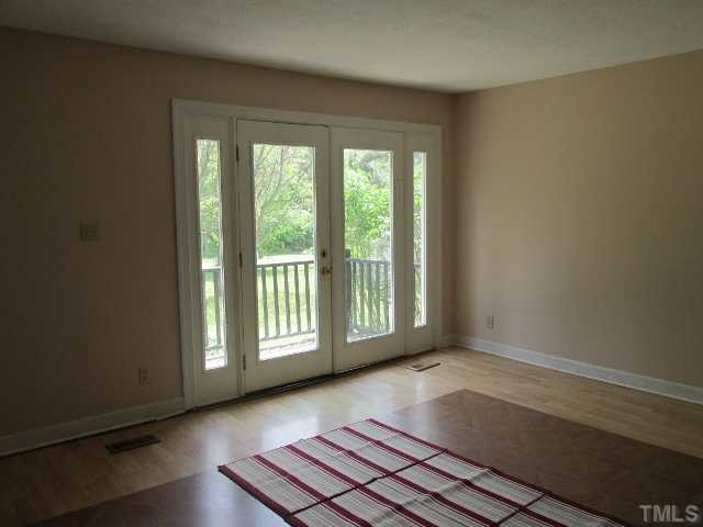 1923 Shaw Road Durham, NC 27704 - Photo 3 of 17 a view of an empty room with wooden floor and a window