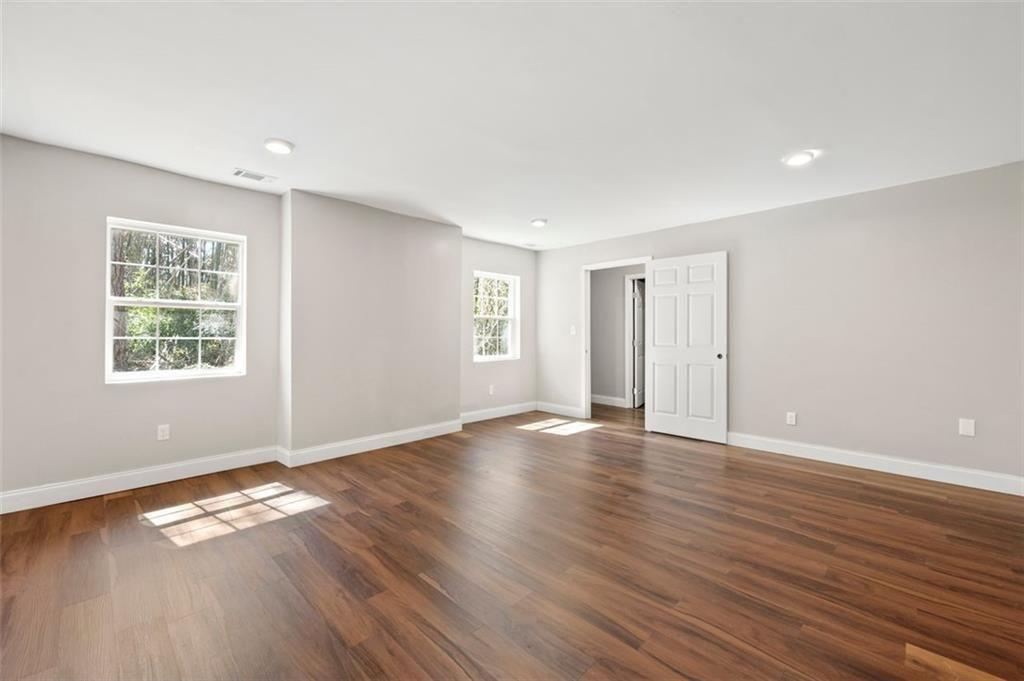 3480 Hogan Road Southwest Atlanta, GA 30331 - Photo 15 of 25 an empty room with wooden floor and windows