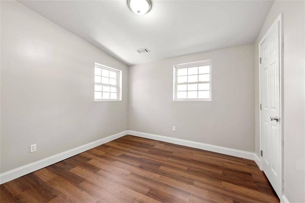 3480 Hogan Road Southwest Atlanta, GA 30331 - Photo 17 of 25 an empty room with wooden floor and windows