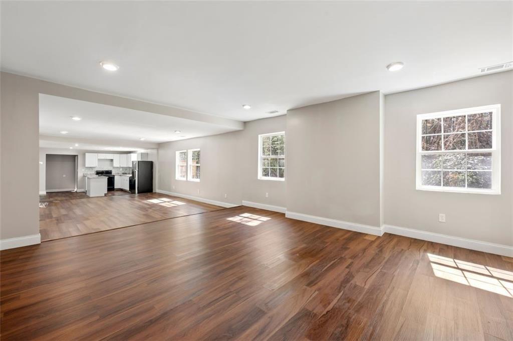 3480 Hogan Road Southwest Atlanta, GA 30331 - Photo 9 of 25 an empty room with wooden floor and windows