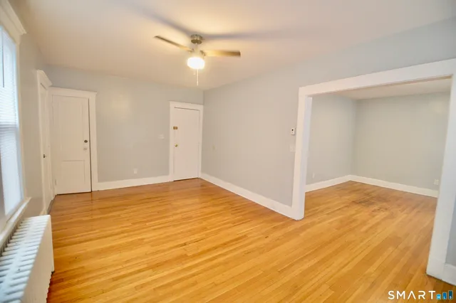 a view of an empty room with wooden floor